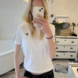 Vit T-shirt - Vit T-shirt från Lyle and Scott. Ränder på axlarna, sparsamt använd. Normal i storlek. Lite skrynklig då den legat nervikt, kan strykas innan leverans☺️