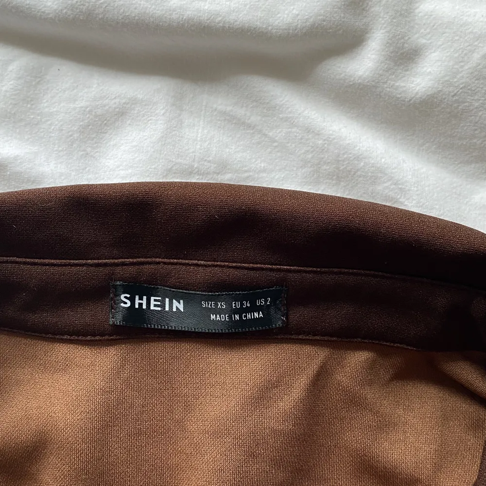 En brun t-shirt klänning med knappt fram till i storlek xs men passar som s. Klänningar.