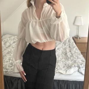 Vit festlig blus  - En vit blus som kan användas både till vardags och fest. Väldigt bra skick och endast använd enstaka gång. Lite genomskinligt tyg med olika detaljer.