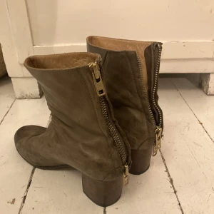 Acne Joli Boots - Beigea/ljusbruna boots från Acne. Helt nysulade och väldigt fina, några fläckar men tycker det ger en schysst patinerad effekt. Otroligt bekväma. Snygg detalj är att de stängs med dragkedja bak. 