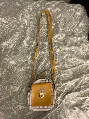 Liten användbar väska - Går att uppna där fram där det finns ett fack, knappt använd och går att ändra axelremmen.