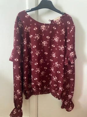 Blommig blus - Ber om ursäkt för dålig bild, men jag säljer denna vackra vinröda blus för billigt pris!