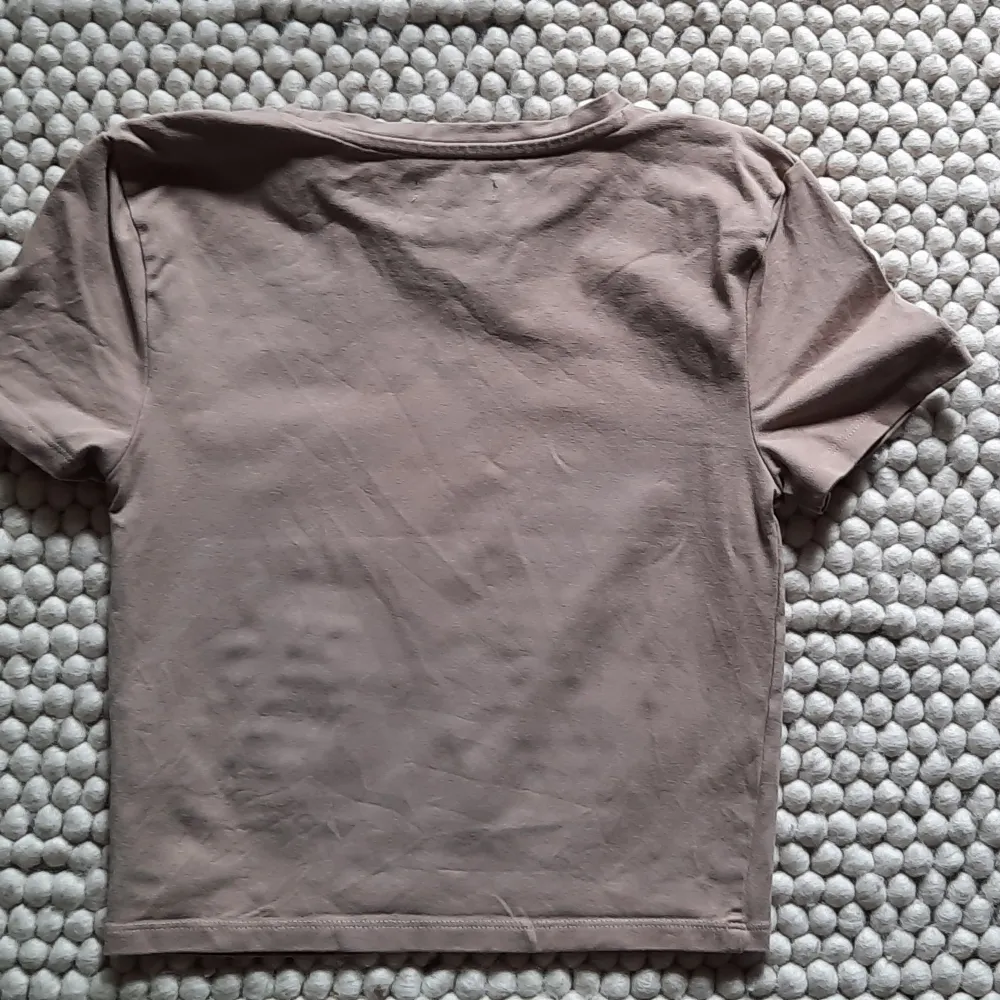 Beige T-shirt från Bik Bok.  Väldigt lite använd  92% Bomull  8 % Elastan  Längd 34 cm. T-shirts.