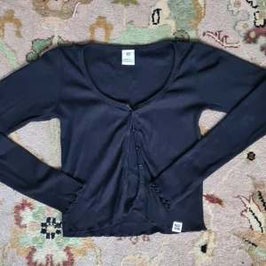 Söt svart top  - Croppad svart top från Lucy & Yak. Gulligt blommönster i tyget. Gjord i 100% bomull 🌻