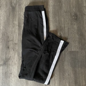 Svarta mjuskisbyxor - Svarta mjukisbyxor med slits från H&M. Använda men fortfarande i bra skick.