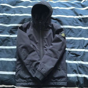 Stone Island jacka - Halloj! Säljer nu denna lite fodrade vind/regnjacka från Stone Island. Jackan är inköp på NK i Stockholm för 3199 kr och är endast använd ett fåtal gånger, skick 9/10. Storleken är 156 eller 12 år gammal men passar något större. 