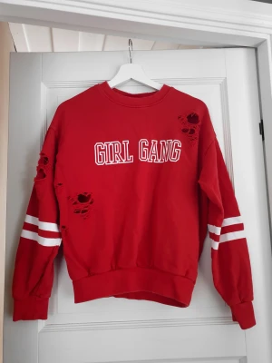Collegetröja röd - Röd collegetröja från Gina Tricot med slitningar. Fint skick. Plagget tvättas och rollas innan jag fraktar iväg 📦 Går med på billigare paketpris vid köp av flera plagg.