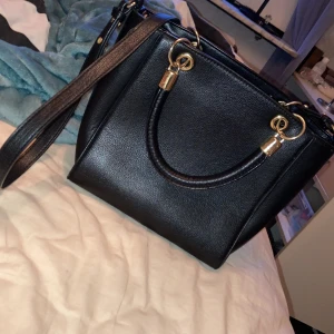 Väska - Säljer en av mina favorit väskor! Säljer den pga av att jag inte använder den lika mycket längre. Man kan även ta bort det bandet och även ställa in det till den längd man vill ha