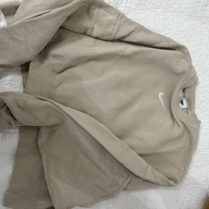 Nike Sweatshirt - Jättefin Nike sweatshirt i färgen beige, lite loose baggy fit. Använd 2 gånger, säljer då jag inte naturligt sträcker mig efter den i garderoben o min garderob kommer spricka. Nypris ca 600