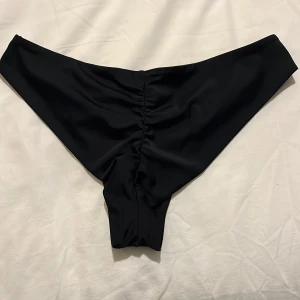 Svart bikiniunderdel - Bikiniunderdel från nelly som aldrig är använda så helt i nyskick. En ”räfflad” kant där bak som ger fin form✨