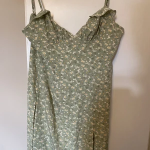 Grön blommig klänning - En grön blommig klänning som tyvärr är för liten, passar mer M än L skulle jag säga ⚡️ skriv för egna bilder.