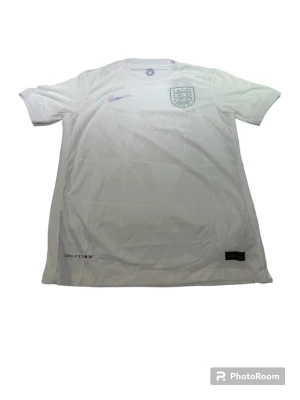 England White jersey - En England tröja i storlek M som är vit. Den är perfekt passande och av hög kvalitet. Dess andningsförmåga gör den idealisk för både matcher och träning.