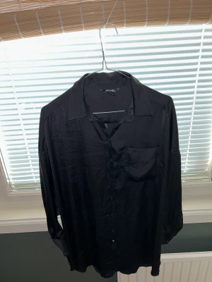 Silkesskjorta svart - Oversized silkesskjorta från monki. Använd endast en gång men har legat i garderoben därav lite skrynklig. 