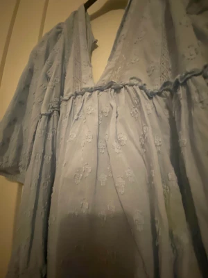 Blå klänning - Jättefin klänning från H&M använd några gånger med är som ny. Säljer för att den inte kommer till användning längre. Den är i en jättefin blå färg och man kan både ha den som strandklänninf och finklänning.
