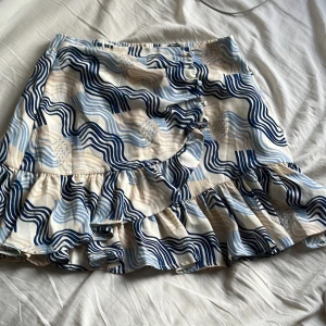 Kjol - En kjol från Gina mönstrad. Volang på framsidan med några knappar. Ändrad någon gång men är i bra sick. 