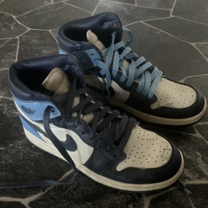 Jordan 1 Obsidian  - Hej! Säljer mina Jordan 1 Obsidians i storlek 38 men passade mig som en 37 och samt nu då en 38. Endast få defekter. Man får med två par marinblåa skosnören och två par vita skosnören. Frakt ingår i priset, alltså är det 550kr inklusive frakt.