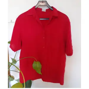 Röd kortärmade skjorta i bra skick. Röda små knappar och en ficka på framsidan. Storlek 40. 🌼 (Färgen är som på första bilden även om den ser lite mer rosa ut på andra) 