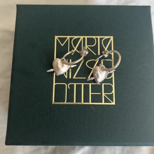 Maria Nilsdotter örhängen  - Säljer mina örhängen från Maria Nilsdotter i modellen ”Tuvstars Heart” knappt använda. Nypris för ett par är 4590kr