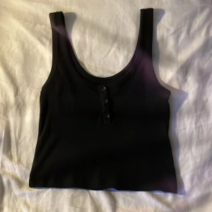 Svart linne🤘🏼 - Jättefint svart ribbat linne från lager 157 i storlek XS med knappar💝 Den är i perfekt skick och aldrig använd💞 Fråga om frakt.