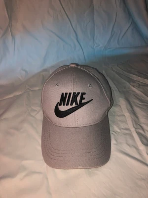 Grå Nike keps - Grå Nike keps använd 1 gång, köpte i Spanien för 150 kr och säljer för 120kr.