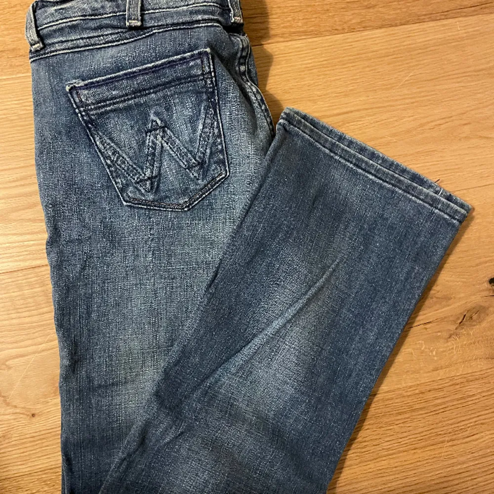 Supersnygga lågmidjade bootcut jeans från Wrangler. Bra skick, dock saknas knappen men det går lätt att sy på en ny! Perfekt längd och går över skorna på mig som är 169 cm. Jeans & Byxor.