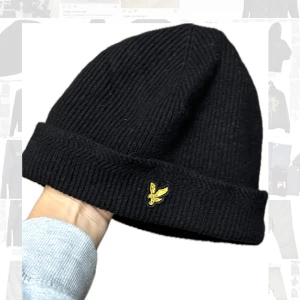 Mössa Lyle and Scott  - Racket rib beanie från Lyle and Scott. Svart. Använt fint skick