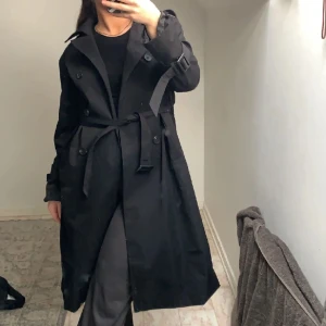 Trenchcoat  - En fin svart trenchcoat som inte kommer till användning, skriv om du har frågor eller vill diskutera priset 🤗