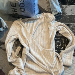 En stickad beige tröja som är lite öppen, och som man kan knuta!❤️ - jätte fin tröja men är lite för stor på mig❤️