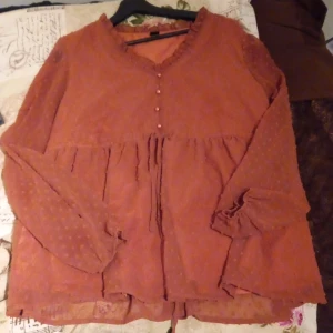 Råsa blus - Råsa blus som är prickig o har knappar vid bröstet. Den e gedterbar då den har ett bälte som man kan spenna blusen på.💞