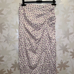 ZARA kjol - Mellanlång kjol från Zara. Lilablommig. Med en ”ihopskrynklig” på ena sidan. Aldrig använd, med prislapp kvar. 