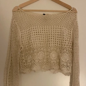 Virkad tröja - Sälje ren superfin vit virkad tröja från H&M. Perfekt att använda över något i vinter eller som en cover-up till stranden. Är åt det croppade hållet och har utsvängda ärmar. 