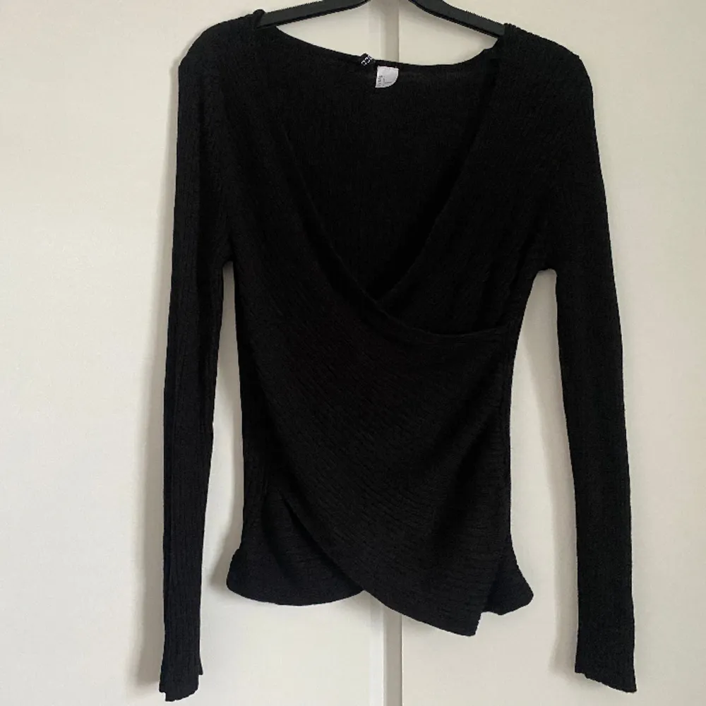 Supersöt svart ribbad tröja som är v-ringad från Hm. Jättefint skick, säljer då den inte kommer till användning längre 💕. Tröjor & Koftor.