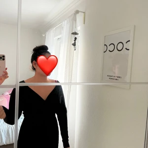 Svart omlottklänning med v-ringning - Säljer en svart kort omlottklänning med lång ärm och djup v-ringning. Klänningen har en figurnära passform och markerad midja, vilket ger en snygg siluett. Perfekt för dig som gillar stilrena och trendiga plagg.