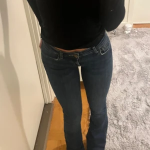 Mörkblå bootcut jeans - Snygga mörkblå jeans med bootcut-modell och låg midja, stretchigt denimtyg som sitter tajt över låren och går ut längst ner 
