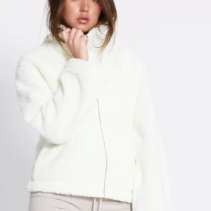 Vit teddyjacka med dragkedja - Mysig vit teddyjacka med hög krage och hel dragkedja framtill. Jackan har två stora fickor och är tillverkad i fluffigt fleece-material. Perfekt till hösten och våren. Den är använd 2 gånger och är som ny. Säljer då den inte kommer till användning💕