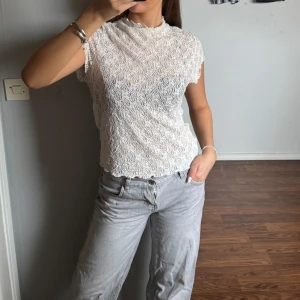 Vit spetsblus  - Säljer en vit, kortärmad blus i spets med hög hals, från HM. Superfin och snygg till allt!