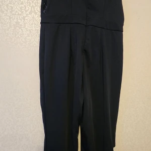 Mörkblå byxdress från SHEIN Curve 0XL - Snygg mörkblå byxdress från SHEIN Curve i storlek 0XL. Byxdressen har omlott-ringning, paljettbroderade detaljer upptill och dragkedja i ryggen. Materialet är mjukt och följsamt, perfekt för dig som vill sticka ut med lite extra glitter.