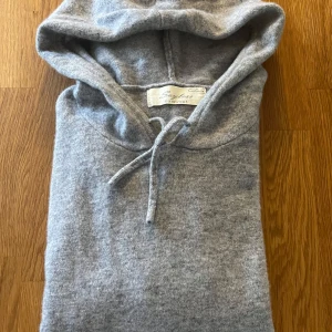 Grå cashmere hoddie från sayless - Mjuk och lyxig grå hoodie från Sayless i 100% cashmere. Tröjan har huva med snörning och långa ärmar, perfekt för dig som vill ha en stilren och bekväm look. Enkel design som funkar till allt och känns riktigt skön mot huden. Priset är absolut inte hugget i sten, bara att höra av sig vid frågor.