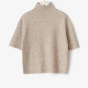 Aldrig använd beige stickad polotröja med kort ärm - Supersnygg stickad polotröja med korta ärmar från Gina tricot. Aldrig använd med prislappen kvar. Nypris 300