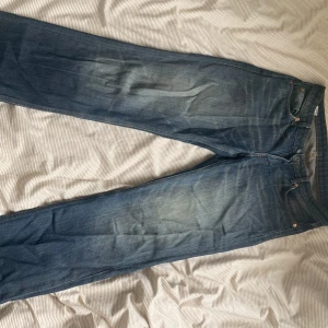 Weekday Arrow Low Straight Jeans blå - Säljer ett par blå Weekday Arrow Low Straight Jeans i klassisk denim med låg midja och raka ben.  Jeansen är knappt använde och i bra skick!