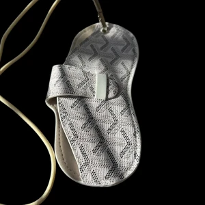 Vit mönstrad sovmask med snörning - Snygg vit sovmask med geometriskt mönster i grått och svart. Masken har en mjuk form som följer ansiktet och ett elastiskt band med snörning för att sitta bekvämt. Perfekt för att blockera ljus när du vill vila eller resa.