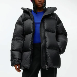 Svart pufferjacka med huva från ARKET - Säljer en svart pufferjacka från ARKET med oversized passform och huva.  Köpt för 2400kr