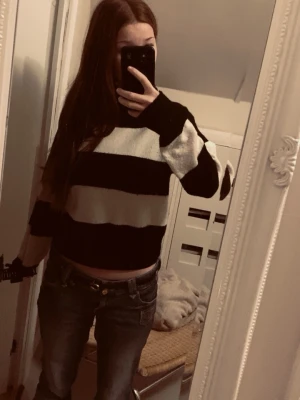 Randig svartvit stickad tröja  - Säljer en stickad tröja från Lindex i storlek 158/164. Tröjan har breda svarta och vita ränder. Perfekt för vintern!! Använd en gång