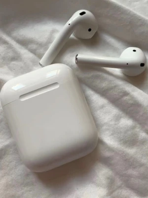 AirPods 2 - Sälja ett par Apple AirPods 2 med laddningsetui. Trådlösa hörlurar med bra ljudkvalitet och smidig anslutning till iPhone och andra Apple-enheter. Finns inga synliga repor/sprickor. 
