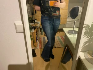 Blå bootcut jeans - Säljer ett par snygga mörkblå bootcut jeans med broderier på bakfickorna. Har sytt in dem lite vid låren för att få dem mer flared och har en liten skavank på en sida men ingen som syns mycket.