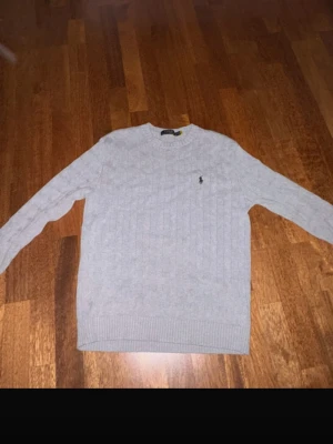 Grå stickad tröja från Polo Ralph Lauren - Säljer en grå kabelstickad tröja från Polo Ralph Lauren. Använd ungefär 3 gånger och är i nyskick. Pris kan diskuteras. Lite stor i storleken. 