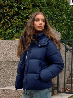 Mörkblå vinterjacka - Säljer en mörkblå pufferjacka med huva och dragkedja framtill. Fodrad och riktigt mysig, passar dig som vill ha en stilren och enkel look. Skriv för fler/egna bilder! Pris går att diskutera