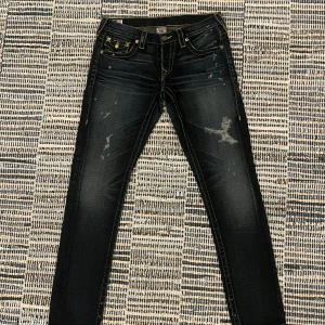 True Religion jeans - Superfina jeans från True Religion med snygga slitningar. Skriv vid frågor!