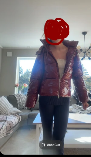 Vinröd pufferjacka från Nelly - Säljer en vinröd pufferjacka från Nelly med glansig yta och huva. Jackan har dragkedja framtill, två fickor med knapp och quiltad design. Perfekt för kalla dagar och har en snygg, lite oversized passform.