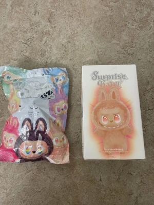 Brun pälsväst med kaninöron - Säljer en brun pälsväst med söta kaninöron från Surprise Baby. Västen har en fluffig look och är designad för att sticka ut med sitt gulliga och lekfulla uttryck. Perfekt för dig som gillar unika och färgglada plagg med lite extra attityd.